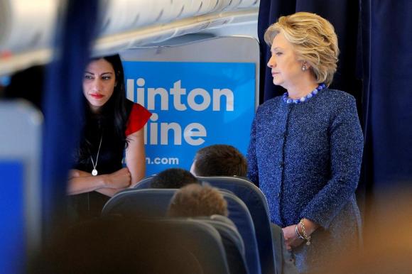 U.S. Democratic presidential nominee Hillary Clinton talks to staff members, including aide Huma Abedin, onboard her campaign plane in White Plains